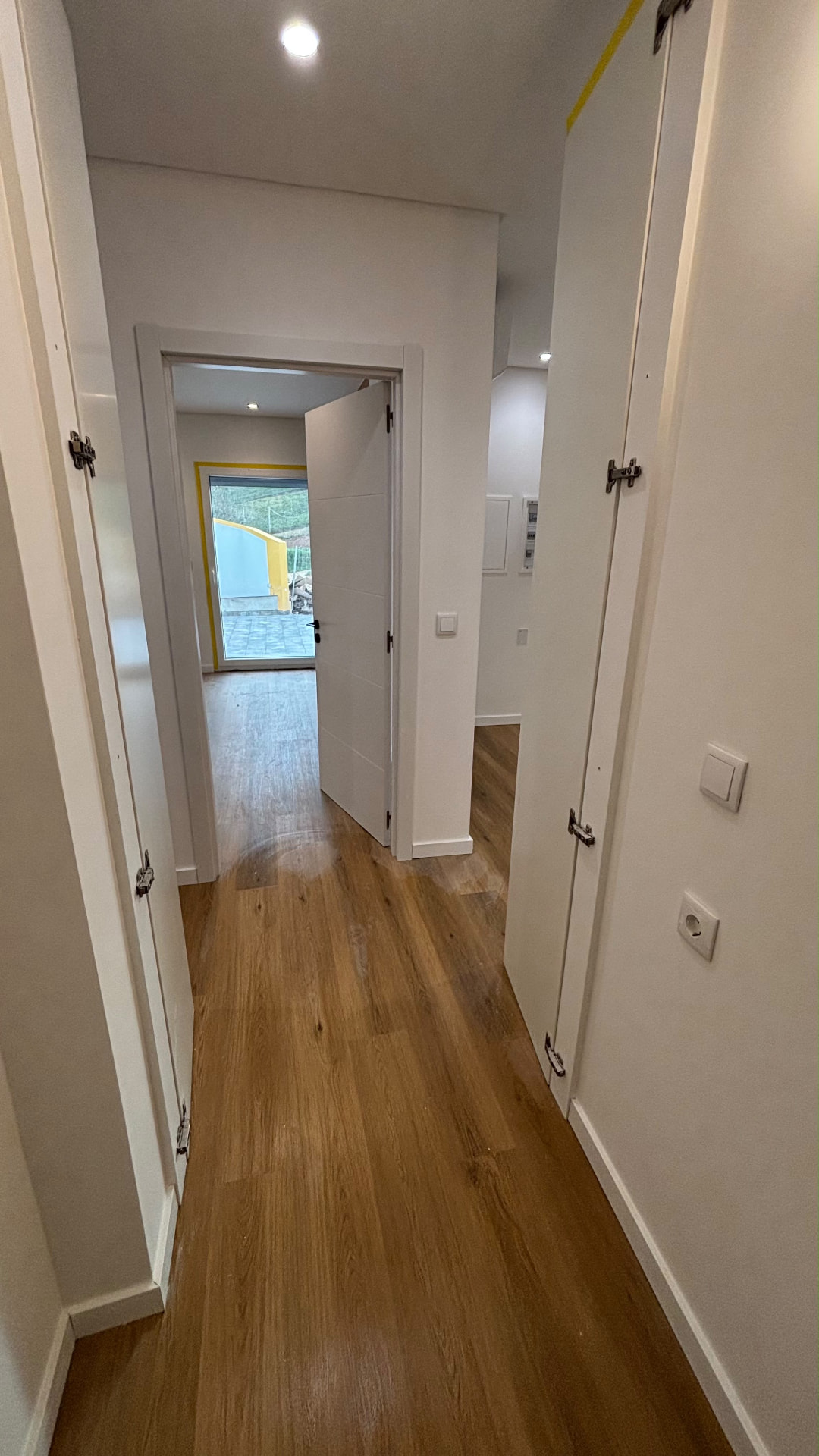 Corredor com piso flutuante e portas lacadas