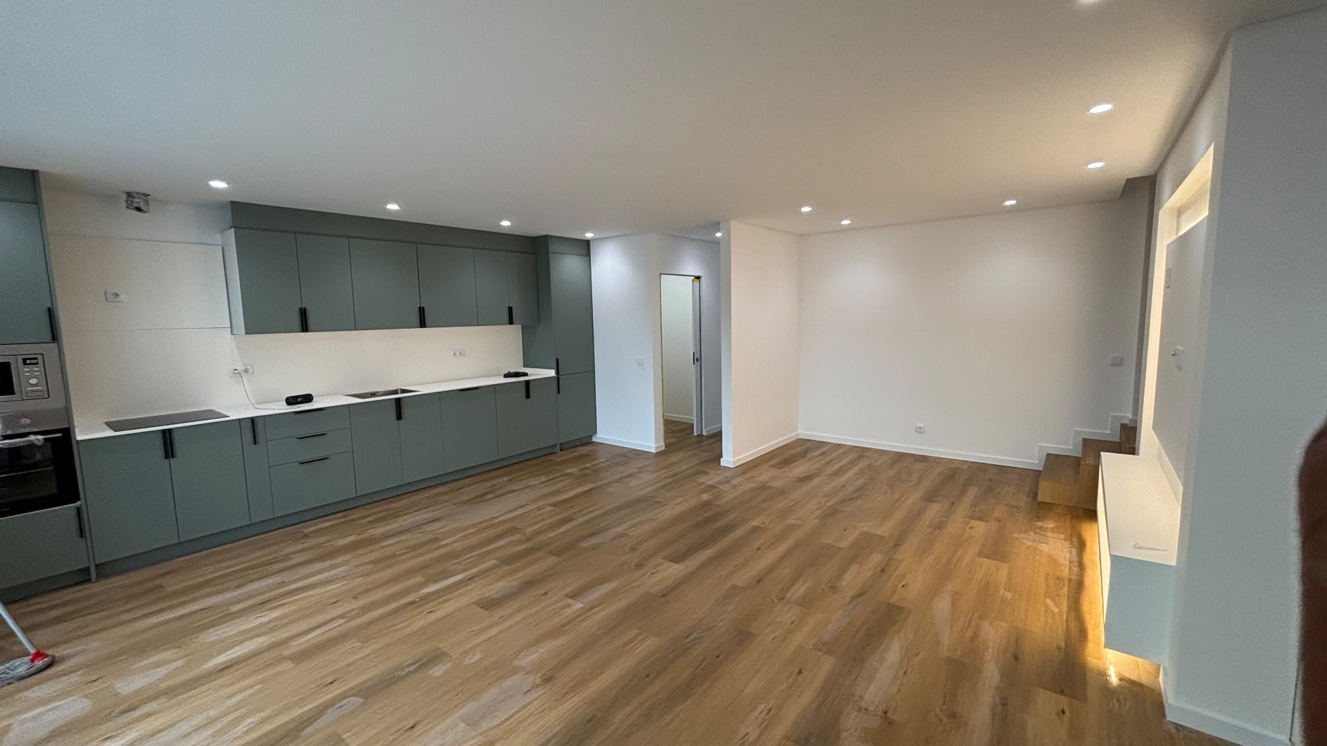 Cozinha em lacado verde aberta para a sala