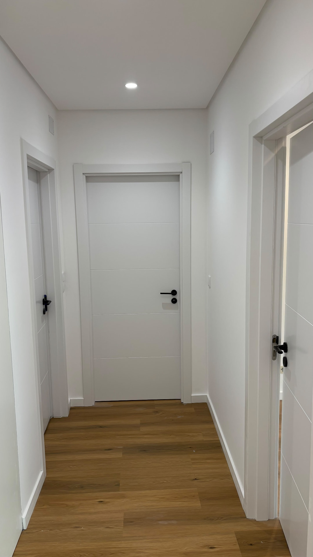 Corredor com portas lacadas e piso flutuante